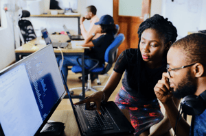 woman and man sitting in front of monitor